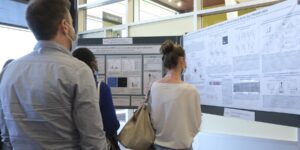 Trois personnes regardent des affiches scientifiques aux Journées de la recherche du Centre de recherche du CHU de Québec–Université Laval.